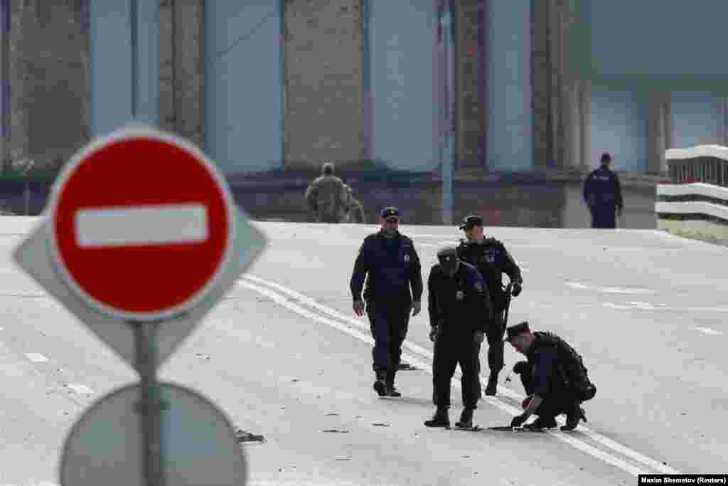 Members of the security services investigate a bridge near the site of a damaged building in Moscow. Moscow Mayor Sergei Sobyanin said the drone strikes occurred around 4 a.m. local time. 