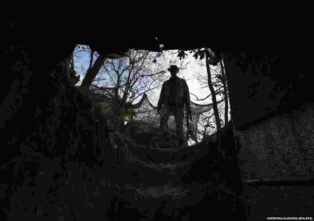 A Ukrainian soldier inspects a former Russian position outside the village of Robotyne near the front line in the Zaporizhzhya region of southern Ukraine on November 4. Russia and Ukraine gave contradictory accounts over the weekend of November 4-5 about what is occurring along the front line in the Zaporizhzhya region, with Moscow saying it has stopped Kyiv's counteroffensive while Ukraine's military claims it is continuing with its attacks.