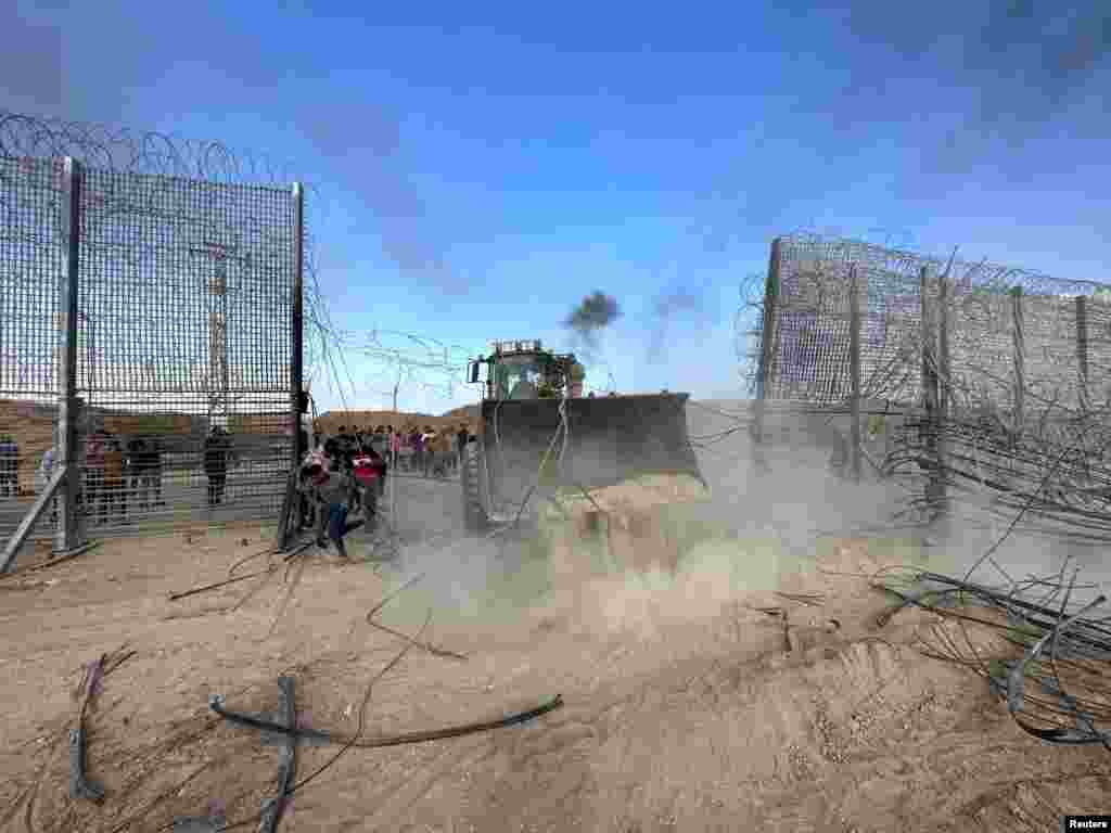 A construction vehicle breaks into the Israeli side of the Israel-Gaza border fence on October 7, 2023. The extremist group Hamas carried out an unprecedented, multi-pronged attack on Israel, firing thousands of rockets as dozens of Hamas fighters infiltrated the heavily fortified border in several locations by air, land, and sea and catching the country off-guard on a major holiday. Hamas has been designated by the United States and the EU as terrorist group and is a key member of Iran's axis.