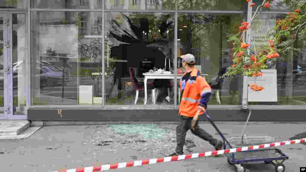 A man walks past a building reportedly damaged in a drone attack.