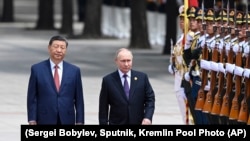 Chinese President Xi Jinpin (left) and Russian President Vladimir Putin as they review an honor guard during a visit to Beijing by the Russian leader last year. (file photo) 
