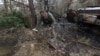 Вайсковы сапэр падбірае неразарваныя часткі касэтнай бомбы, якія засталіся пасьля ўварваньня Расеі каля вёскі Мотыжын Кіеўскай вобласьці, 10 красавіка 2022 