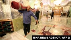 Workers clean up the scene following an armed attack at the Shah Cheragh mausoleum in the Iranian city of Shiraz on October 26, 2022. 