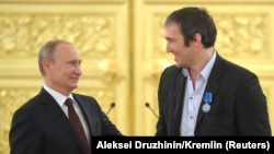 Президент России Владимир Путин (слева) приветствует капитана Александра Овечкина во время встречи с игроками, тренерами и официальными лицами сборной России — победителями чемпионата мира по хоккею с шайбой среди мужчин 2014 года во время церемонии награждения в Кремле 