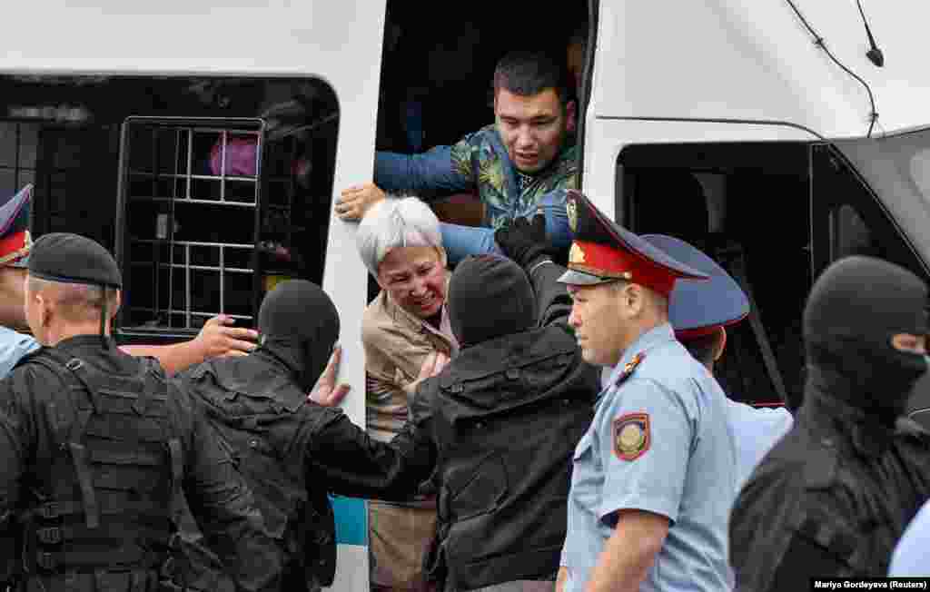 Казак полициясы нааразылык билдирип чыккандардын көбүн автоунаага күчтөп отургузуп жатты. Алматы, 9-июнь, 2019-жыл. 
