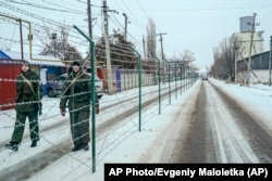 Russian guards patrol an area along the Russian side of the fence in Milove.