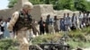 A British soldier next to the wreckage of a car used in a suicide attack on May 21