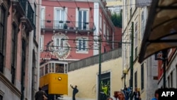 (FILES) A man takes pictures of the Elevador da Gloria (Gloria funicular) in Lisbon on November 8, 2023.