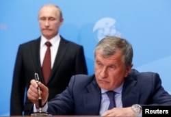 President Vladimir Putin (back) ruled that state-controlled Rosneft, headed by Igor Sechin (right), could participate in the Bashneft privatization.