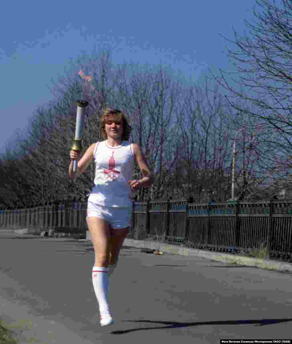 A woman running with the Olympic torch ahead of the opening of the games. 