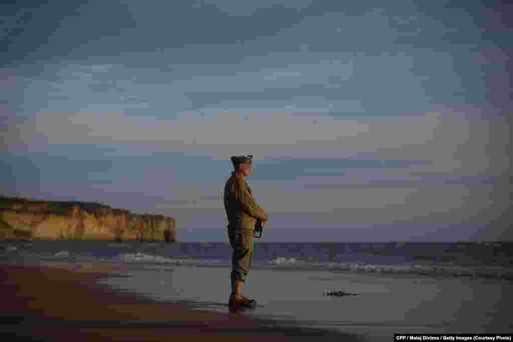 Honorable Mention, General News: A man dressed in a World War II-era U.S. uniform pays his respects to those who died in the D-Day landings in Normandy, France, on June 6, 2014, the 70th anniversary of the Allied invasion. (Denik/Martin Divisek) 