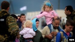 Migrants board a train after crossing the border between Macedonia and Greece on September 8.
