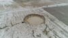 Iran - a sinkhole caused by land subsidence, caused by excessive ground water usage, caused by drought. AP video screen grab