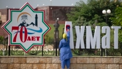 Уборщица на фоне городских украшений в честь 70-летия Ахмата Кадырова, архивное фото