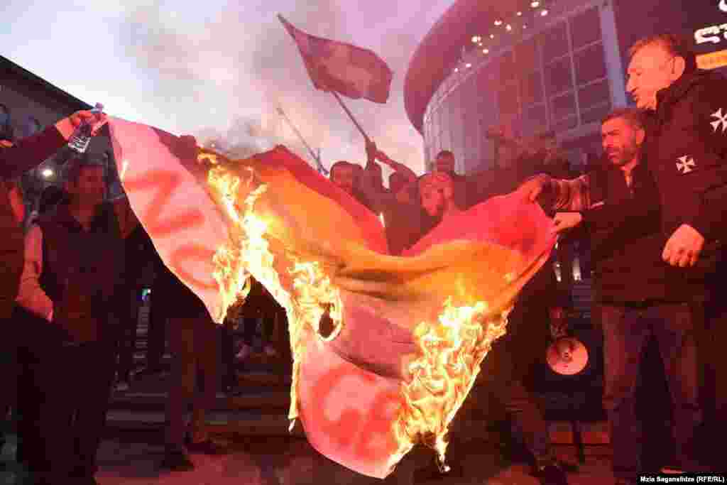 Demonstrators burn an LGBT flag before the screening in Tbilisi. 