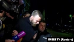 Jack Shepherd is escorted by police in Tbilisi on January 23.