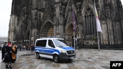 A police car drives in front of the Cologne Cathedral on December 24.